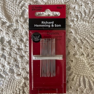May include: A package of Richard Hemming & Son darning needles, size 7, containing 12 needles. The needles are silver and are packaged in a red and clear plastic container. The package has black and white text.