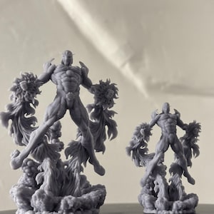 May include: Two gray 3D-printed figurines of a muscular humanoid figure with a helmet and energy-like formations around the body. The figures are posed mid-air, with one larger than the other. The base of each figure is a cloud-like formation.