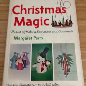 Könnte beinhalten: Ein Vintage-Buch mit dem Titel "Christmas Magic" von Margaret Perry. Das Cover zeigt Illustrationen von Weihnachtsdekorationen und -schmuck, darunter Papierarbeiten und einen Schneemann. Das Buch verspricht über 200 Illustrationen, davon 45 in Farbe.