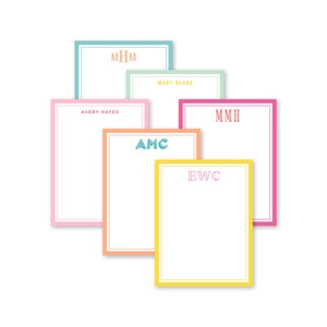 May include: Five colorful notepads with different monograms. The notepads are stacked on top of each other. The monograms are "MHM", "MARY BLAKE", "AMC", "MMH", and "EWC".