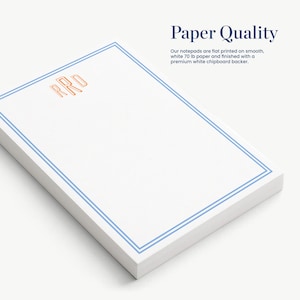 a set of white notepads with blue borders, arranged on a white surface.