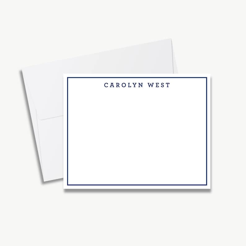 A blank white card with a blue border, placed on top of an envelope.
