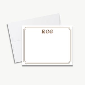 a blank card with a decorative border, placed on top of an envelope.
