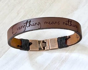May include: Brown leather bracelet with a metal clasp and the engraved text "Everything means nothing".