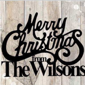 Peut inclure: Panneau en métal noir avec le texte "Merry Christmas from The Wilsons" sur un fond en bois.