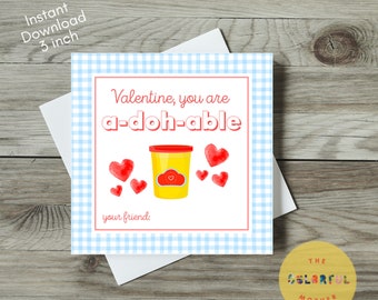 May include: A Valentine's Day card with a blue and white gingham background. The card features a red and yellow playdough container with the text "Valentine, you are a-doh-able" and red hearts. The card also includes the text "your friend".