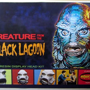 May include: Creature from the Black Lagoon all resin display head kit. The box features a colorful image of the creature's head. The kit includes four different head sculpts, each with a different expression. The box also features the Classic Monster Toys logo.