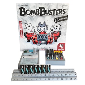Könnte beinhalten: Das Brettspiel "Bomb Busters" mit einem Cartoon-Design mit einer Katze und zwei Kaninchen. Das Spiel enthält einen Timer, nummerierte Kacheln und beschriftete Kacheln. Die Box zeigt den Timer bei 00:02.