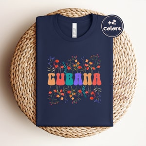 May include: A navy blue t-shirt with a colorful floral design and the word "CUBANA" in a retro font.
