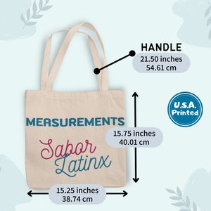 May include: Beige tote bag with the text "Sabor Latinx" in pink and teal. The bag measures 15.75 inches (40.01 cm) high, 15.25 inches (38.74 cm) wide, and has a handle length of 21.50 inches (54.61 cm). The bag is printed in the U.S.A.