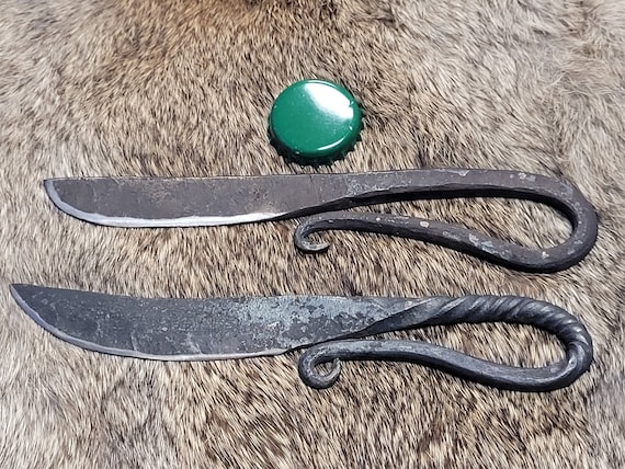 A hand-forged knife with a wrapped-tail handle AND a flint striker spine that moonlights as a bottle opener — three tools in one forged piece.