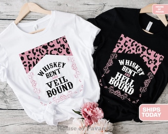 Op de afbeelding: Twee witte en zwarte T-shirts met een roze luipaardprint en de tekst "Whiskey Bent and Veil Bound" en "Whiskey Bent and Hell Bound".