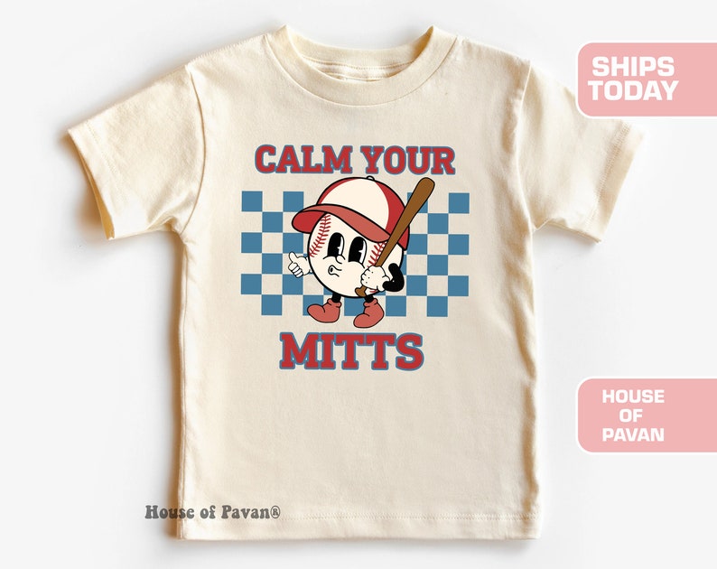 May include: A cream colored t-shirt with a cartoon baseball character holding a bat. The text "Calm Your Mitts" is printed on the shirt.