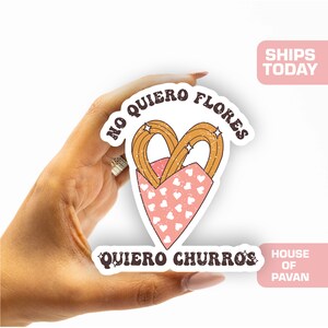 May include: A sticker with a pink heart-shaped container filled with two churros. The text on the sticker reads "No quiero flores, quiero churros".