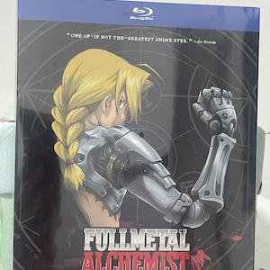 K&ouml;nnte beinhalten: Ein Blu-ray-Disc-Geh&auml;use mit der Anime-Serie Fullmetal Alchemist. Das Cover zeigt einen Charakter mit blonden Haaren und einem mechanischen Arm vor einem schwarzen Hintergrund mit einem roten und wei&szlig;en Design. Der Text auf dem Geh&auml;use lautet "Fullmetal Alchemist: Die komplette Serie auf Blu-ray".