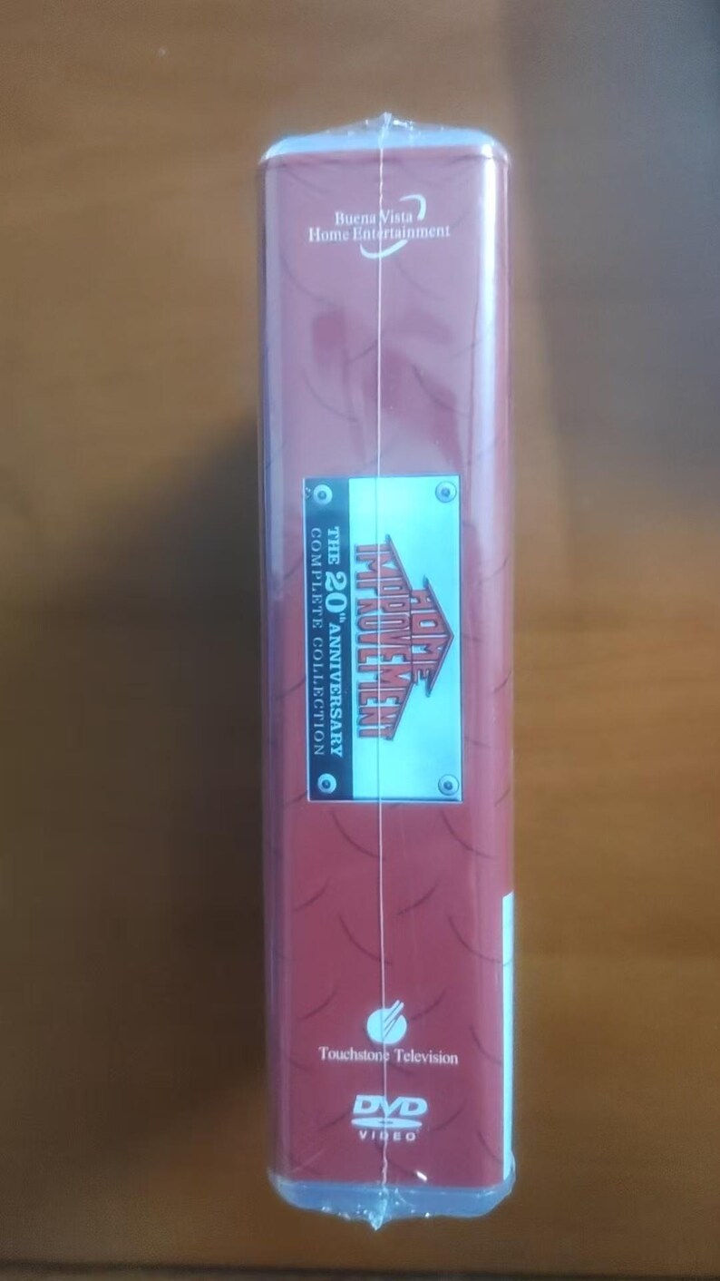 May include: A DVD box set of "Home Improvement: The 20th Anniversary Complete Collection." The box is wrapped in clear plastic and features a red and maroon design with the show's logo and the Buena Vista Home Entertainment logo.