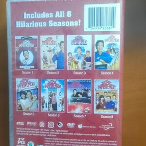 May include: DVD set of the TV show "Home Improvement", featuring all eight seasons. The packaging is red with images from the show's episodes. The text "Includes All 8 Hilarious Seasons!" is visible.