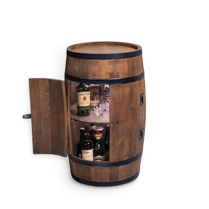 Può includere: Un mobile a forma di botte in legno con anta a cerniera, che rivela ripiani pieni di bottiglie di liquore e bicchieri. Il mobile è realizzato in legno scuro con fasce e ferramenta in metallo nero.