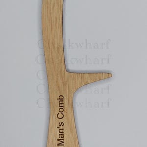 May include: A wooden comb with the text "Bald Man's Comb" engraved on the handle.