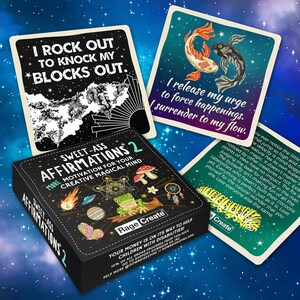 Może przedstawiać: Czarne pudełko z kolorowym wzorem przedstawiającym żabę, motyla, UFO i grzyb. Pudełko jest oznaczone jako "Sweet-Ass Affirmations 2" i "More Motivation for Your Creative Magical Mind". Pudełko zawiera r&oacute;wnież tekst "Your money is on its way to help children with disabilities! 10% of all gross proceeds from this deck go to supporting Downside Up Inc. Help more @downsideupinc // downsideupinc.org"