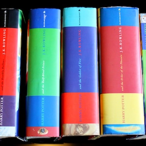 Puede incluir: Un conjunto de siete libros de tapa dura con lomos coloridos. Los libros son todos parte de la serie Harry Potter de J.K. Rowling. Los títulos son "Harry Potter y las Reliquias de la Muerte", "Harry Potter y el Príncipe Mestizo", "Harry Potter y el Cáliz de Fuego", "Harry Potter y la Orden del Fénix", y "Harry Potter y la Cámara Secreta".
