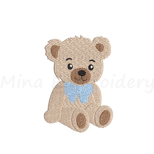 May include: A tan teddy bear embroidery design with a blue bow tie. The bear has brown accents on its ears, paws, and nose. The design is on a white background. The text "Mina Embroidery" is in the lower left corner.