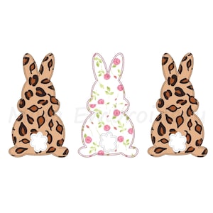 May include: Three Easter bunny cutouts. Two are brown with a leopard print pattern, and one is white with a pink floral pattern. Each bunny has a white, scalloped tail and a stitched outline.