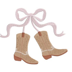 May include: An embroidered design featuring two tan cowboy boots with decorative stitching, suspended from a light pink bow and ribbons. The boots have brown heels and accents. The design is on a white background.