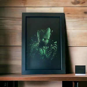 May include: A framed print of a green and black illustration of a character from the Guardians of the Galaxy movie. The character is Groot, a tree-like humanoid with glowing green eyes. The print is in a black frame with a white mat.