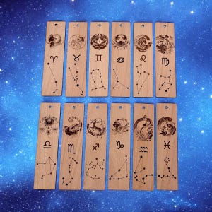 Könnte beinhalten: Zwölf Holzbuchzeichen mit Sternzeichen und Sternbildern. Jedes Lesezeichen zeigt ein anderes Sternzeichen und das dazugehörige Sternbild. Die Lesezeichen sind aus hellbraunem Holz gefertigt und haben eine natürliche Oberfläche.