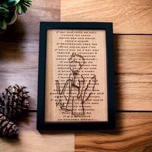 May include: A framed wooden plaque with a poem engraved in French. The poem is about love and loss, and it says "C'est une folie de hair toutes les roses parce que une epine vous a piqué... d'abandonner tous les rêves parce que l'un d'entre eux ne s'est pas réalisé, de renoncer à toutes les beautés parce qu'un éphoud... C'est un choix de condamner toutes les amitiés parce qu'une d'elles vous a trahi, de ne plus croire à l'amour parce qu'un cœur vous a fait souffrir... Il n'y a pas de plus grande chose que la haine, il n'y a pas plus bête que la vengeance, il n'y a pas plus triste que la solitude... Il y aura toujours une autre direction, il y aura toujours un autre ami, un autre amour, une autre nouvelle, pour chaque fin. Il y a toujours un nouveau départ..."