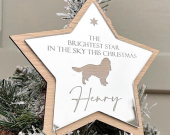 May include: A star-shaped Christmas tree ornament with a light wood frame and a mirrored center. The mirrored surface features the text "THE BRIGHTEST STAR IN THE SKY THIS CHRISTMAS", a dog silhouette, and the name "Henry".