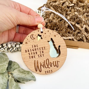 May include: A wooden ornament with a cat silhouette and the text "The brightest star in the sky Willow 2023".