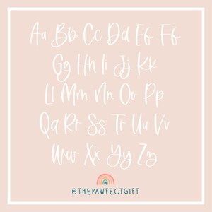 May include: A white alphabet in a handwritten font on a light pink background. The letters are arranged in rows, starting with Aa and ending with Zz. A rainbow with a blue, green, orange, yellow, and pink color scheme is at the bottom of the image with the text "@THEPAWFECTGIFT".