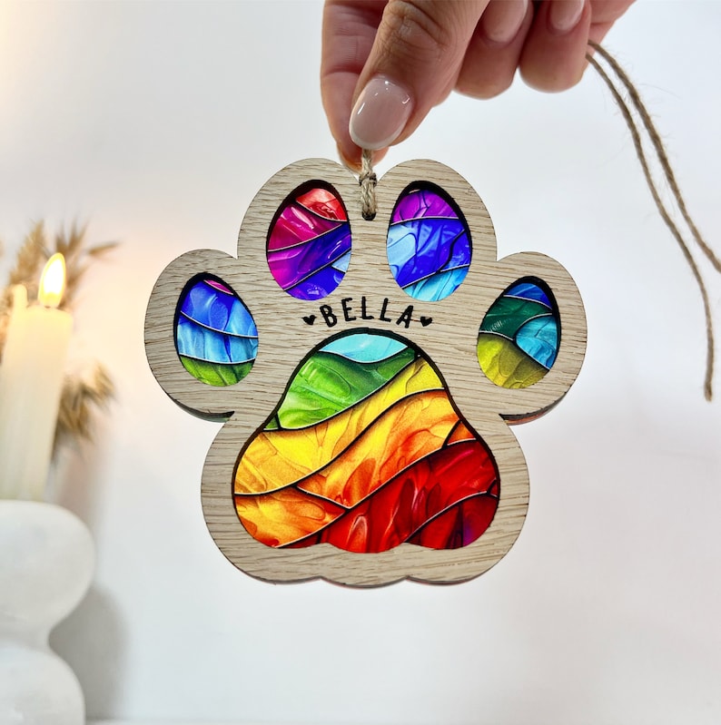 Peut inclure: Ornement en bois en forme de patte d'animal avec un motif arc-en-ciel et le nom "Bella" grav&eacute;.