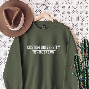 May include: A green sweatshirt with the text "CUSTOM UNIVERSITY SCHOOL OF LAW" in white.