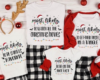May include: A collection of white Christmas-themed tops and pyjamas. The tops display phrases such as "Most Likely to Watch All the Christmas Movies" and "Most Likely to Be Santa's Favourite." The pyjamas are black and white checked.