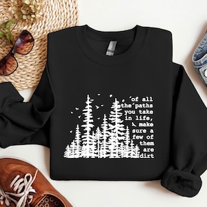 May include: Black sweatshirt with a white graphic of trees and the text "of all the paths you take in life, make sure a few of them are dirt".