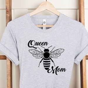 May include: Gray t-shirt with a black bee graphic and the text "Queen Mom" printed on it.
