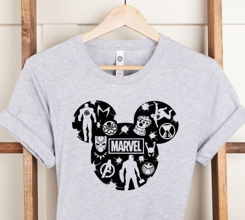 May include: Gray t-shirt with a black Mickey Mouse silhouette design featuring Marvel characters and the word "MARVEL".
