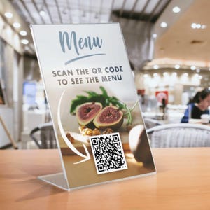 May include: A clear acrylic menu holder with the word "Menu" in a script font. The text "SCAN THE QR CODE TO SEE THE MENU" is below. The image on the menu shows figs and walnuts. A QR code is in the lower right corner.