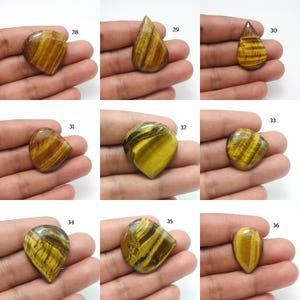 May include: Nine polished tiger's eye gemstones in various shapes, including teardrop and oval. The stones display a mix of golden brown and black bands, with a glossy finish. Each stone is held in a hand, showcasing the natural patterns and colours.