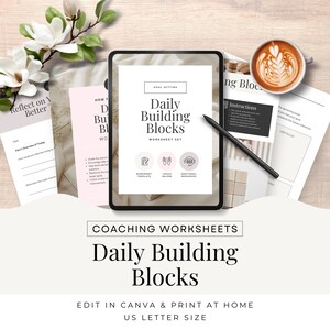 May include: A digital tablet displaying a worksheet titled "Daily Building Blocks" with a goal setting theme. The worksheet includes icons for a workbook template, coach helper, and additional resources. The tablet is on a wooden surface with a cup of coffee and a pen.
