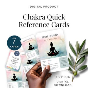 May include: A set of Chakra Quick Reference Cards, a digital product. The cards are 12.7 x 17.8 cm and feature yoga poses and chakra information. The cards are held by a person. The text on the cards includes "Root Chakra" and "7 Cards."