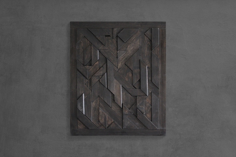 May include: A dark wood wall art piece with a geometric pattern. The piece is made up of many small wooden pieces that are arranged in a complex design.