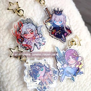 Puede incluir: Cuatro llaveros de acr&iacute;lico con personajes de estilo anime chibi y cierres dorados en forma de estrella. Los dise&ntilde;os incluyen una figura de pelo blanco, un personaje coronado con una espada, una figura de pelo oscuro en un marco y una sirena. El texto dice ART BY SAPHIRYA - SAPHIRYA.STORENVY.COM.