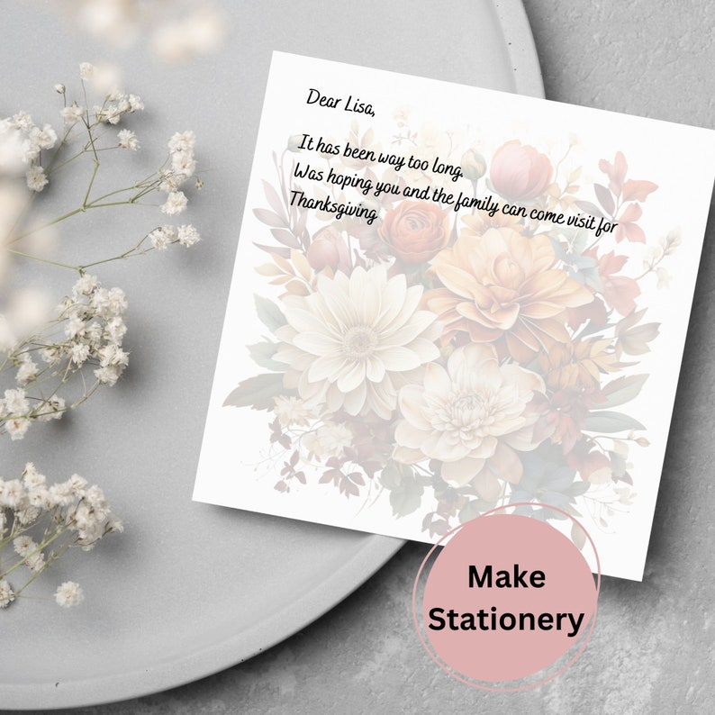 May include: A white card with a floral design and the text "Dear Lisa, It has been way too long. Was hoping you and the family can come visit for Thanksgiving." The card is on a gray surface with a white flower.