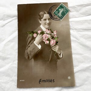 Década de 1910 - Postal francesa antigua - Hombre con guirnalda de flores - Postal antigua escrita - Con la frase "Amitiés" / "Todo lo mejor"
