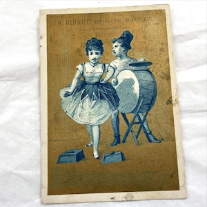 Antike französische Werbekarte – H. Ribaut Juwelier und Uhrmacher – Blaue und goldene Lithographie eines Zirkusmädchens und Zirkusmanns – Ende des 19.Jhs