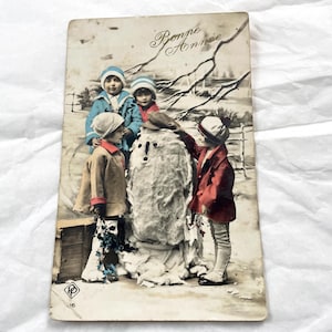 1909 - Carte postale française ancienne - Enfants jouant - Carte postale française avec des enfants et un bonhomme de neige et les mots « Happy New Year »